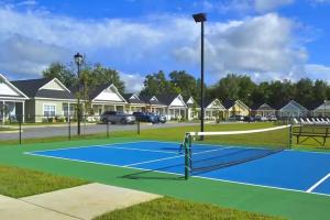 a tennis court in a residential neighborhood with houses at The Cottages 2BR 2BA Dothan Pool Dog Park Pickle Ball Gym in Midland City