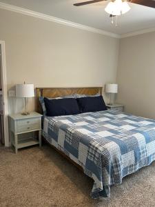 a bedroom with a blue and white bed and two night stands at The Cottages 2BR 2BA Dothan Pool Dog Park Pickle Ball Gym in Midland City