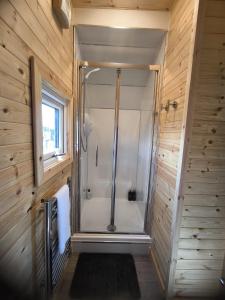 a walk in shower in a bathroom with wooden walls at Aurora Skye in Breakish +46 photos