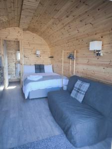 a bedroom with a bed and a couch at Aurora Skye in Breakish