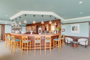 a kitchen with a bar with blue and yellow chairs at Pestana Bahia Praia Nature & Beach Resort in Vila Franca do Campo