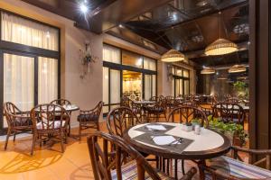 a restaurant with tables and chairs and windows at Pestana Bahia Praia Nature & Beach Resort in Vila Franca do Campo