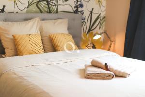 a white bed with two towels on it at GC - Au Vent Du Kent in Wissant