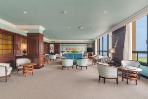 a hotel lobby with chairs and a table and windows at Pestana Bahia Praia Nature & Beach Resort in Vila Franca do Campo