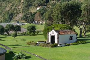 a small chapel in the middle of a green field at Pestana Bahia Praia Nature & Beach Resort in Vila Franca do Campo
