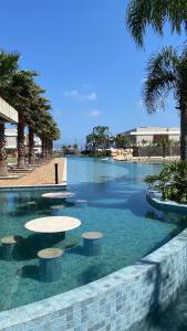 una piscina con tavoli in acqua di Casa em Resort Privado Alto Padrão a Capão da Canoa