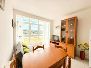 a living room with a table and a couch at Apartamento Saica by ALÔGA in Corcubión