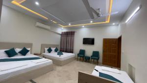 een hotelkamer met twee bedden en een tv bij Midways Guest House and Hotels in Islamabad