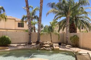 - une piscine avec une fontaine dans une cour agrémentée de palmiers dans l'établissement Riviera Retreat, à Sun Lakes