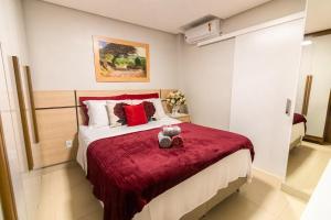 a bedroom with a bed with a red blanket at OZPED Casas Particulares localização Cruzeiro in Brasilia