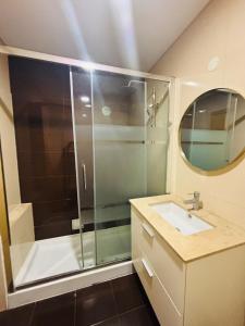 a bathroom with a shower and a sink and a mirror at Vista Gama in Santa Iria da Azóia