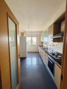 a kitchen with a sink and a stove top oven at Vista Gama in Santa Iria da Azóia