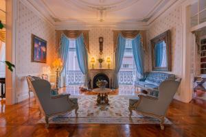 a living room with a fireplace and a couch and chairs at Palácio das Especiarias in Lisbon