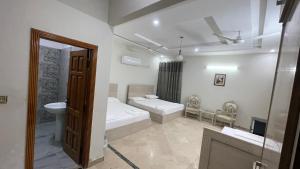 een badkamer met 2 bedden, een wastafel en een spiegel bij Midways Guest House and Hotels in Islamabad +37 foto's