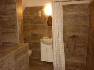 a bathroom with a sink and a toilet and a shower at R4 Rolléder Apartman-ház in Siklós +42 photos