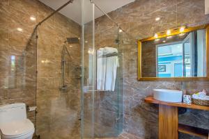 Un baño con ducha de cristal y un inodoro. en Riverside Dorm and Restaurant, en Hoi An