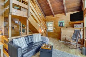 a living room with a couch and a tv in a cabin at Ellijay Cabin 7 Mi to Dtwn Hot Tub and Mtn Views in Ellijay