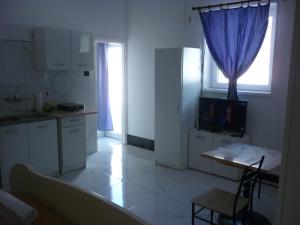 a kitchen with a table and a blue curtain at R4 Rolléder Apartman-ház in Siklós