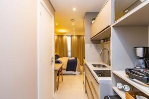 una piccola cucina con tavolo e una camera di Studio Aconchegante com A/C no All Batel - BAT0821 a Curitiba