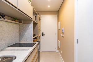 una cucina con piano di lavoro e porta di Studio Aconchegante com A/C no All Batel - BAT0821 a Curitiba
