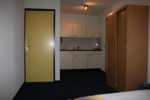 Habitación con puerta amarilla y cocina en Hotel Hardenberg en Hardenberg