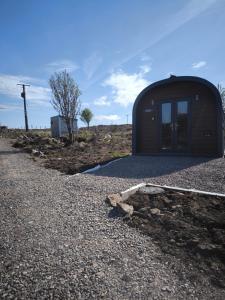 a small building on the side of a gravel road at Aurora Skye in Breakish