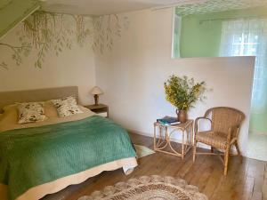 ein Schlafzimmer mit einem Bett, einem Tisch und einem Stuhl in der Unterkunft Les ambiances du Coly, La chambre Vézère in Condat-sur-Vézère