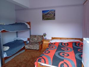 a bedroom with two bunk beds and a chair at Ξενώνας στα Θεοδώριανα 2 - Guesthouse Theodoriana 2 in Theodóriana
