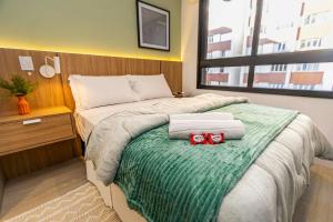 una camera da letto con un letto con due archi rossi sopra di Requinte e Conforto no All Batel - BAT0924 a Curitiba