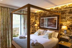 ein Schlafzimmer mit einem Bett in einer Steinmauer in der Unterkunft Ribeira Sacra a Orilla Rio Miño Casas do Pincelo in Pincelo
