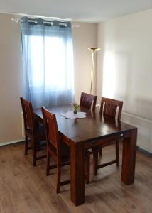 a dining room table with four chairs and a window at Große Landhauswohnung in Ramhusen +12 photos