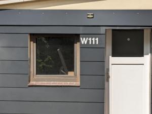 a blue building with a window and a white door at Werkswohnung Hemmingstedt Heide in Hemmingstedt