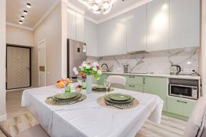 a kitchen with a table with plates and flowers on it at Mechta in Astana