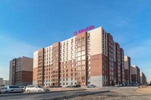 a building with a sign on the top of it at Mechta in Astana