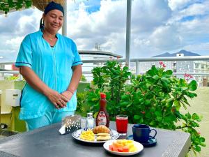 a woman standing next to a table with food on it at Hotel Brisas Del Mar Suite in Santa Marta