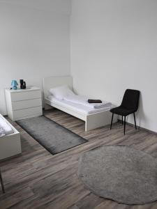 una camera con un letto, una sedia e un tappeto di 3 Zimmer Loftwohnung in Itzehoe a Itzehoe