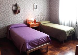 two beds in a room with purple sheets and a table at VILLA Amena WI-FI AC Giardino privato in SantʼAntonio