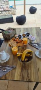a wooden table with breakfast foods on it at Residence Ribellinu in Pianottoli-Caldarello