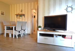 a living room with a flat screen tv on a entertainment center at FeWo Sol Mare Whg2 in Kellenhusen