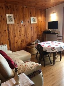 Una sala de estar con una mesa y un televisor. en Le Beau Rivage, en Publier
