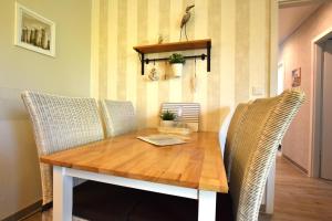a dining room table with wicker chairs and a laptop on it at FeWo Sol Mare Whg2 in Kellenhusen