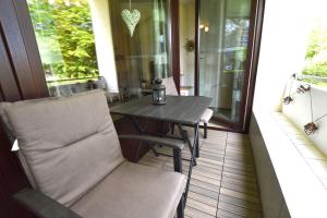 a table and a chair on a screened porch at FeWo Sol Mare Whg2 in Kellenhusen +12 photos
