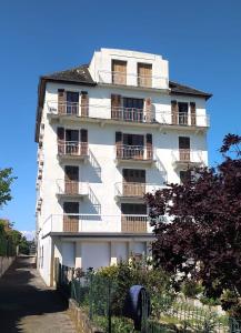 Un edificio blanco con balcones a los lados. en Le Beau Rivage, en Publier