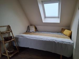 Una cama pequeña en una habitación con ventana. en Appartement à 3 minutes de Dinard, en La Richardais