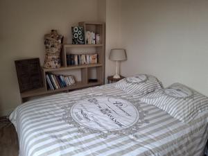 Un dormitorio con una cama con una estantería. en Appartement à 3 minutes de Dinard, en La Richardais