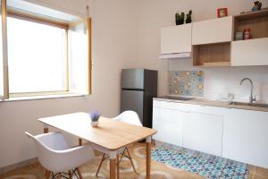 eine Küche mit Tisch und Stühlen und einem Kühlschrank in der Unterkunft Cilento View in San Martino + 22 Fotos