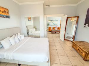 une chambre avec un lit blanc et un miroir dans l'établissement 3bd Little Italy Cottage A++ Location, à San Diego