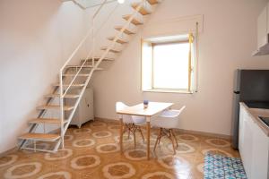 Zimmer mit einem Tisch und einer Wendeltreppe in der Unterkunft Cilento View in San Martino