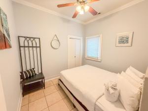 une chambre avec un lit et un ventilateur de plafond dans l'établissement 3bd Little Italy Cottage A++ Location, à San Diego