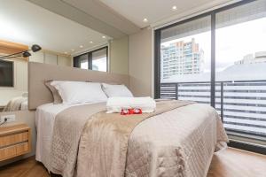 ein Schlafzimmer mit einem großen Bett und einem großen Fenster in der Unterkunft Studio no All Batel com Cama Articulada - BAT1805 in Curitiba